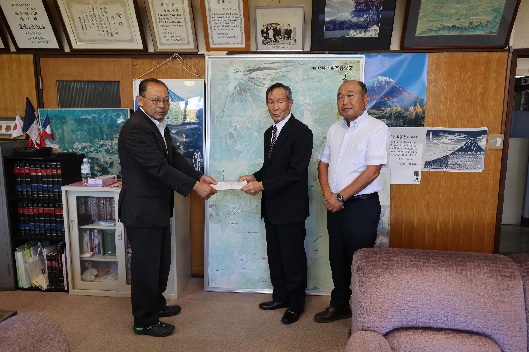 村長へ検討結果報告書を提出する正副委員長の様子の写真