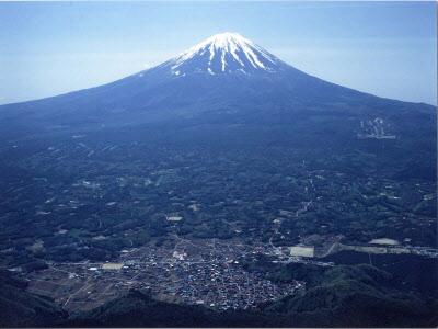 雪を被った富士山をバックに映る鳴沢村全景の写真