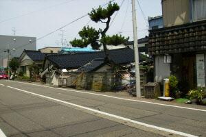 地震で倒壊した道路沿いの家屋が並ぶ写真