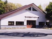 白い壁に三角屋根の建物である鳴沢村屋内ゲートボール場の写真