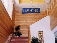 「遊学館」と書かれた青い看板が階段の踊り場に飾られている写真